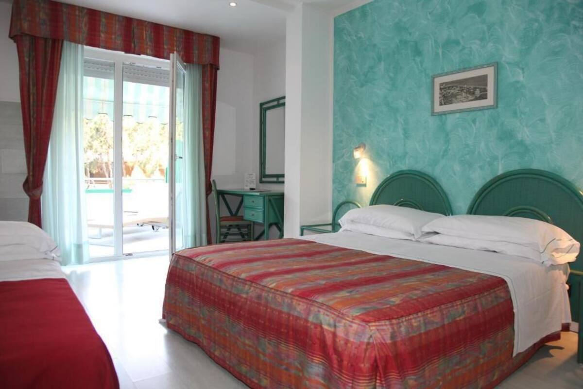 Een hotelkamer met een bed, een bureau en een stoel.