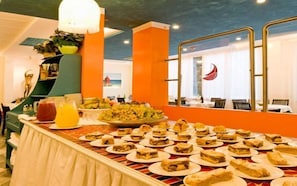 Un buffet proposant divers plats et une salade de fruits.