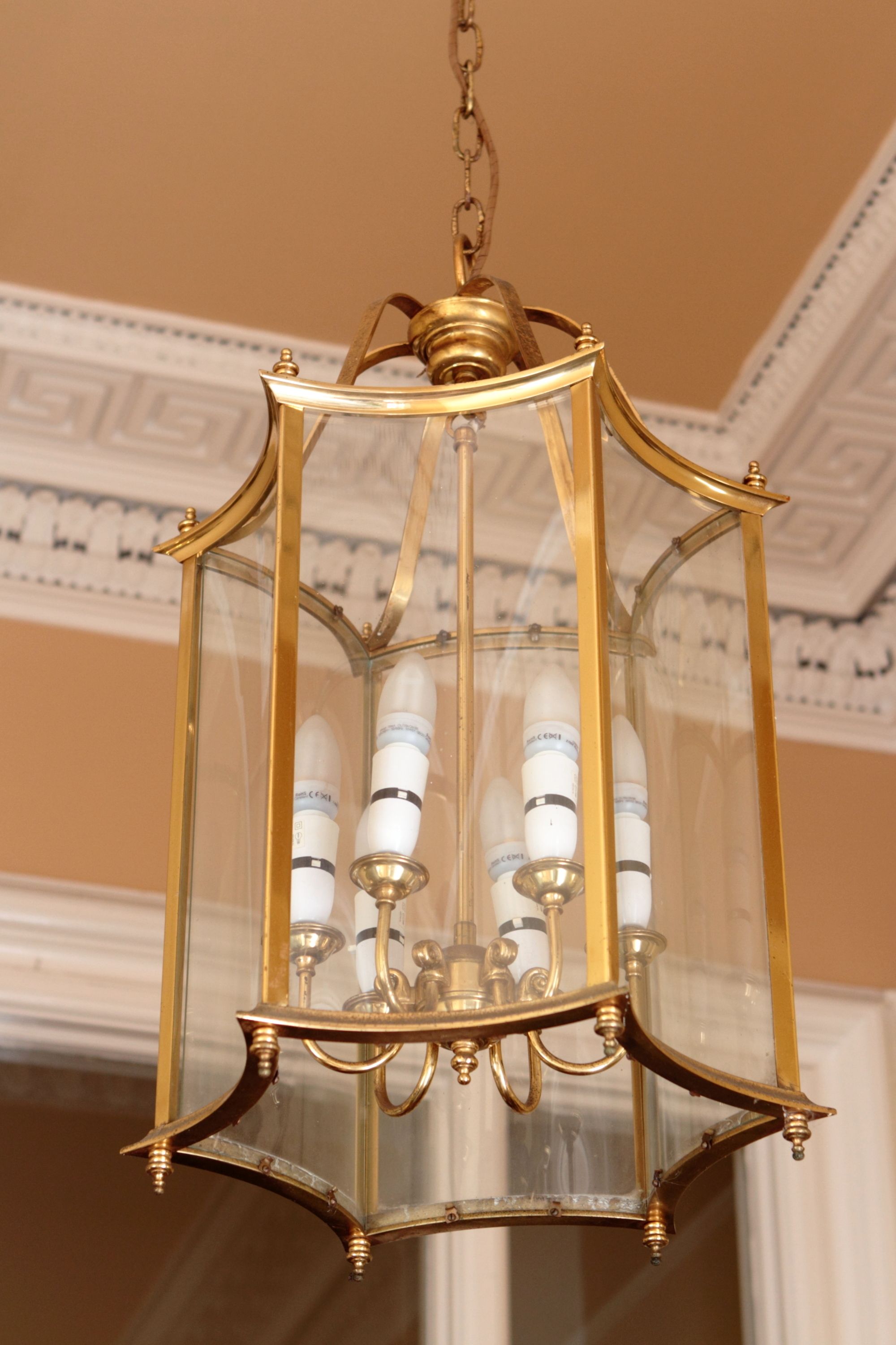 Un candelabro con recinto de vidrio y lámparas que imitan velas.