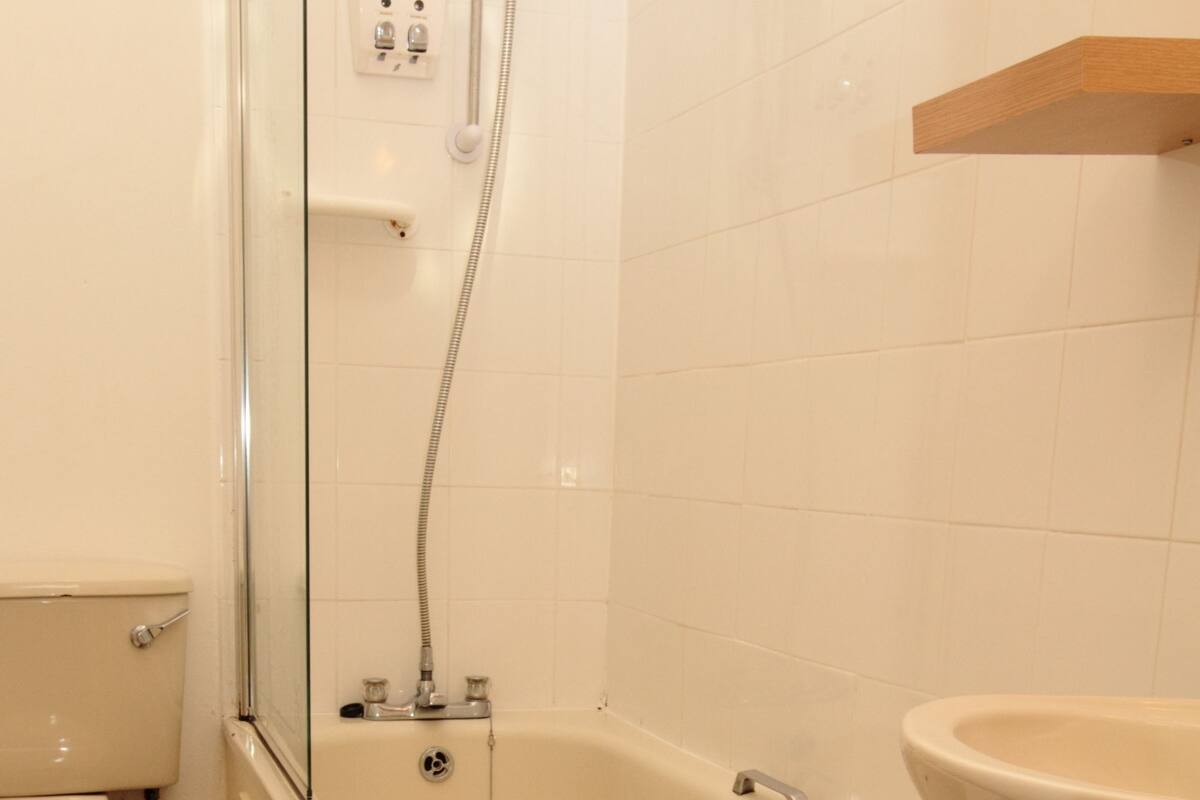 A bathroom with a bathtub, toilet, and sink.