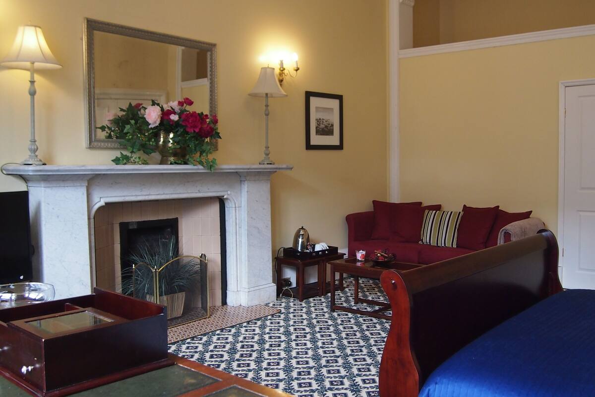 A living room with a fireplace, a sofa, a coffee table, and a patterned floor.