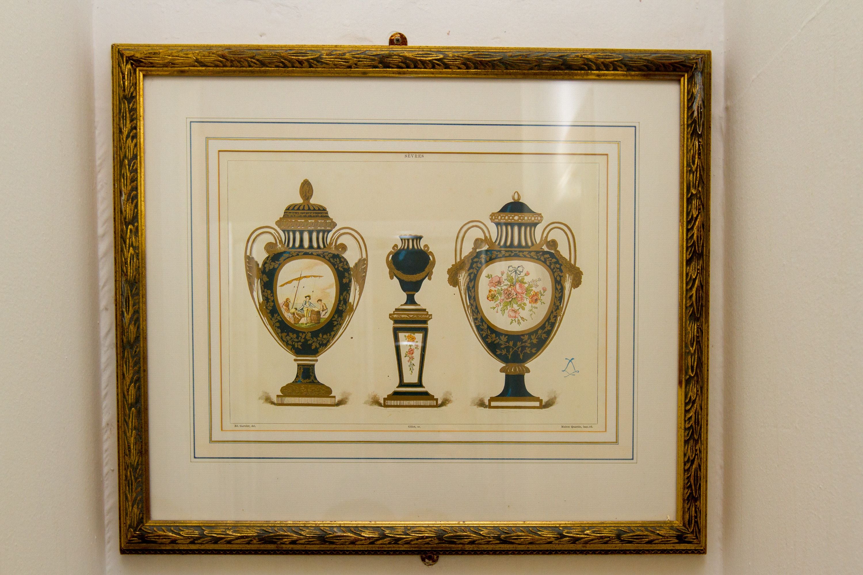 Une œuvre d’art encadrée représentant trois vases richement décorés.