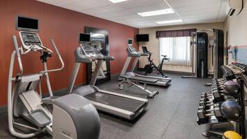 A fitness center with treadmills, an elliptical, a stationary bike, and free weights.