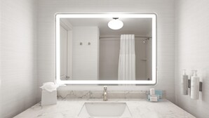 Une salle de bain avec un lavabo en marbre, un grand miroir, un distributeur de serviettes et un rideau de douche.