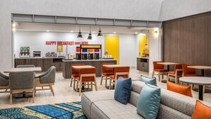 Un espace moderne dédié au petit-déjeuner, avec des sièges et un comptoir.