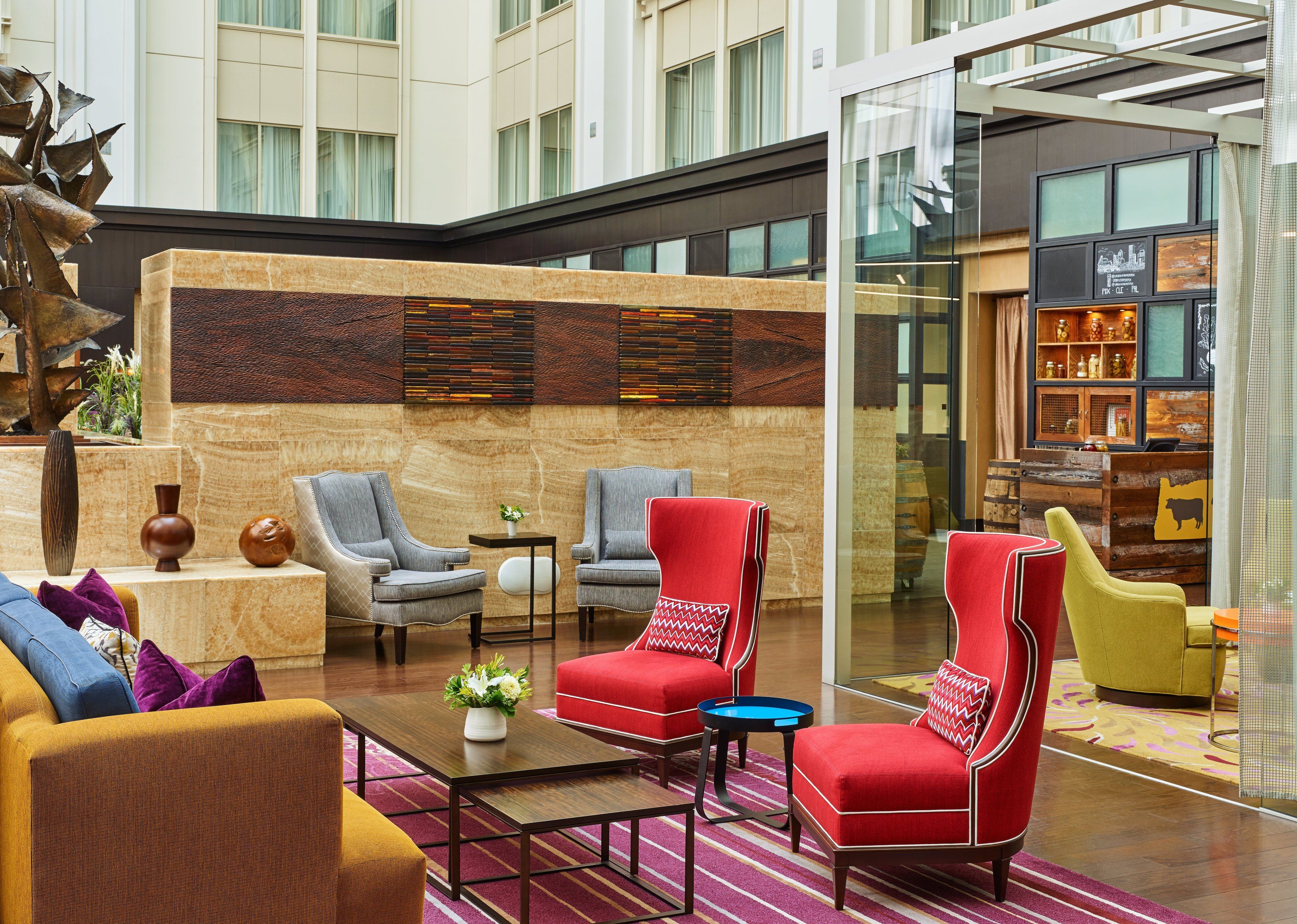 A lobby with seating areas, a reception desk, and a decorative wall.