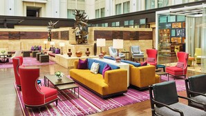 A spacious lobby with a central seating area, a decorative sculpture, and a glass display case. - The Nines, a Luxury Collection Hotel, Portland (Portland)