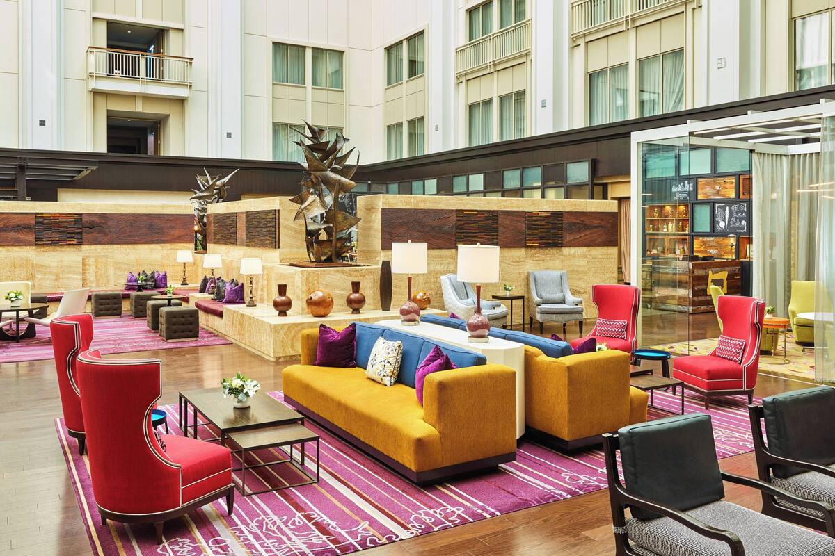 A spacious lobby with a central seating area, a decorative sculpture, and a glass display case.