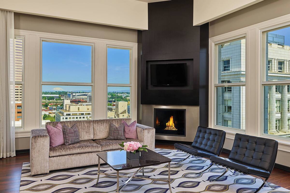 A modern living room with a sofa, a coffee table, and a fireplace.