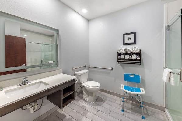 A modern bathroom with a white sink, toilet, and glass shower enclosure.