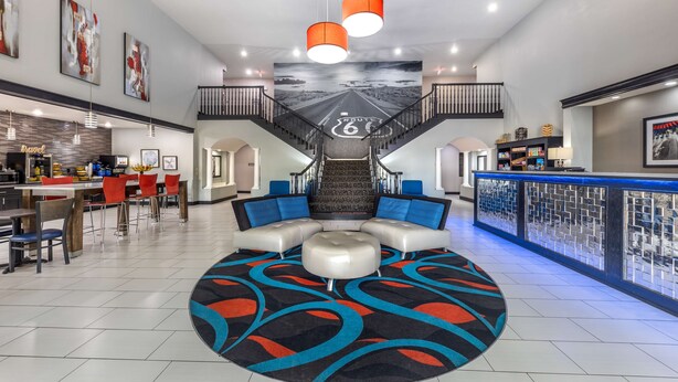 Un hall d’entrée spacieux avec un espace salon central, un escalier et un bar.