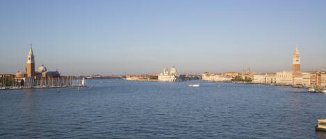 A waterfront cityscape with prominent historical buildings and a clear sky.