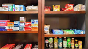 Regale mit einer Auswahl an Lebensmitteln, Getränken und Pflegeartikeln, darunter Snacks und Erfrischungen.