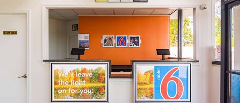 A reception area with a 'Staff Only' sign, framed pictures, and a large number '6' sign.