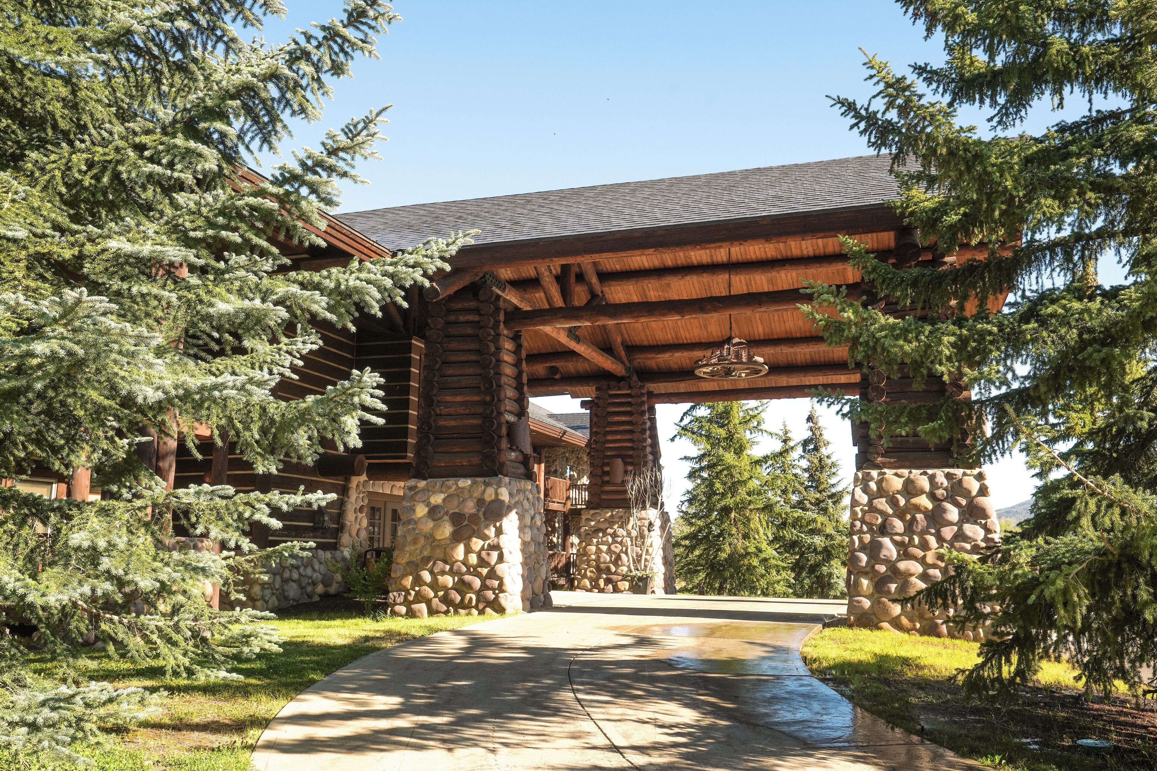 A log cabin with a stone foundation, wooden beams, and a covered entrance.