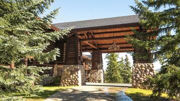 A log cabin with a stone foundation, wooden beams, and a covered entrance.