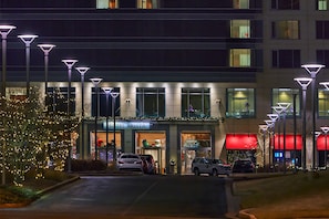 A hotel entrance with a sign reading "HOTEL ARISTA," cars parked in front, and decorative lights. - Hotel Arista (Naperville)