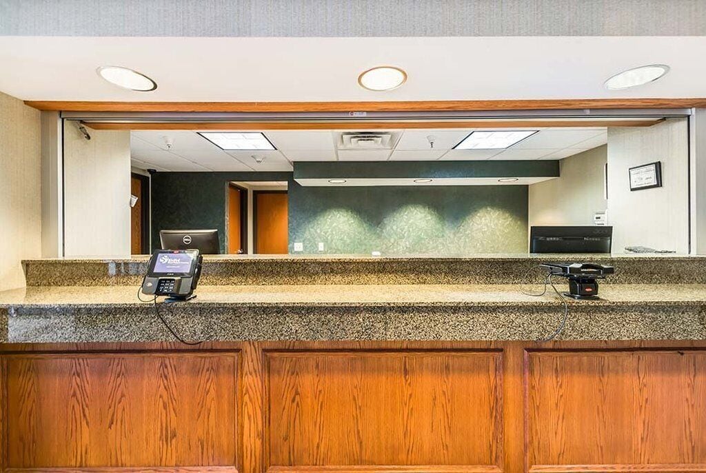 A reception area with a counter, a phone, and a small desk with a computer.