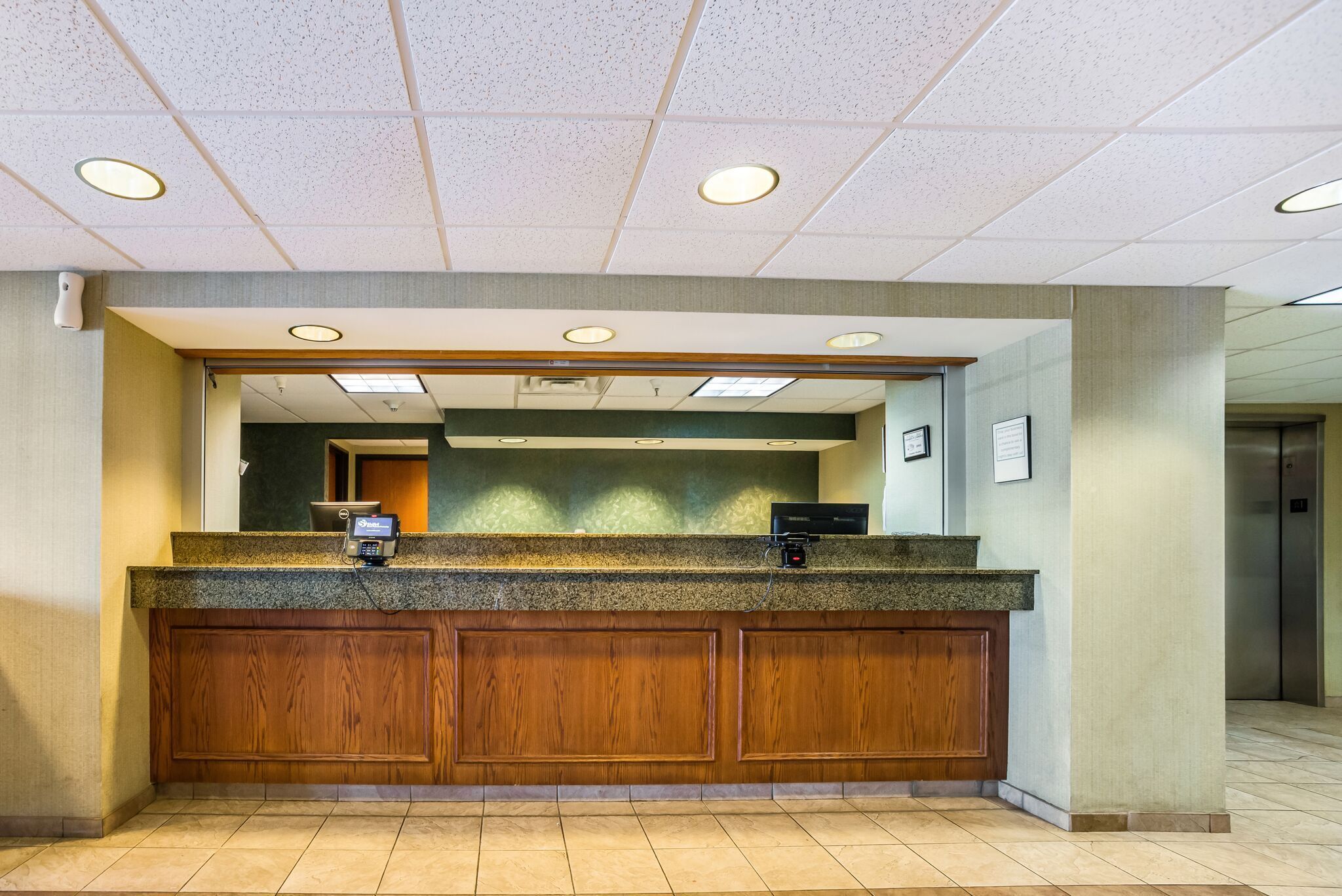 A reception desk with a wooden panel design, a built-in phone, and a computer.