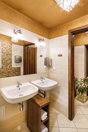 A bathroom with two sinks, a mirror, and a wooden cabinet. - David Boutique Hotel (Kraków)