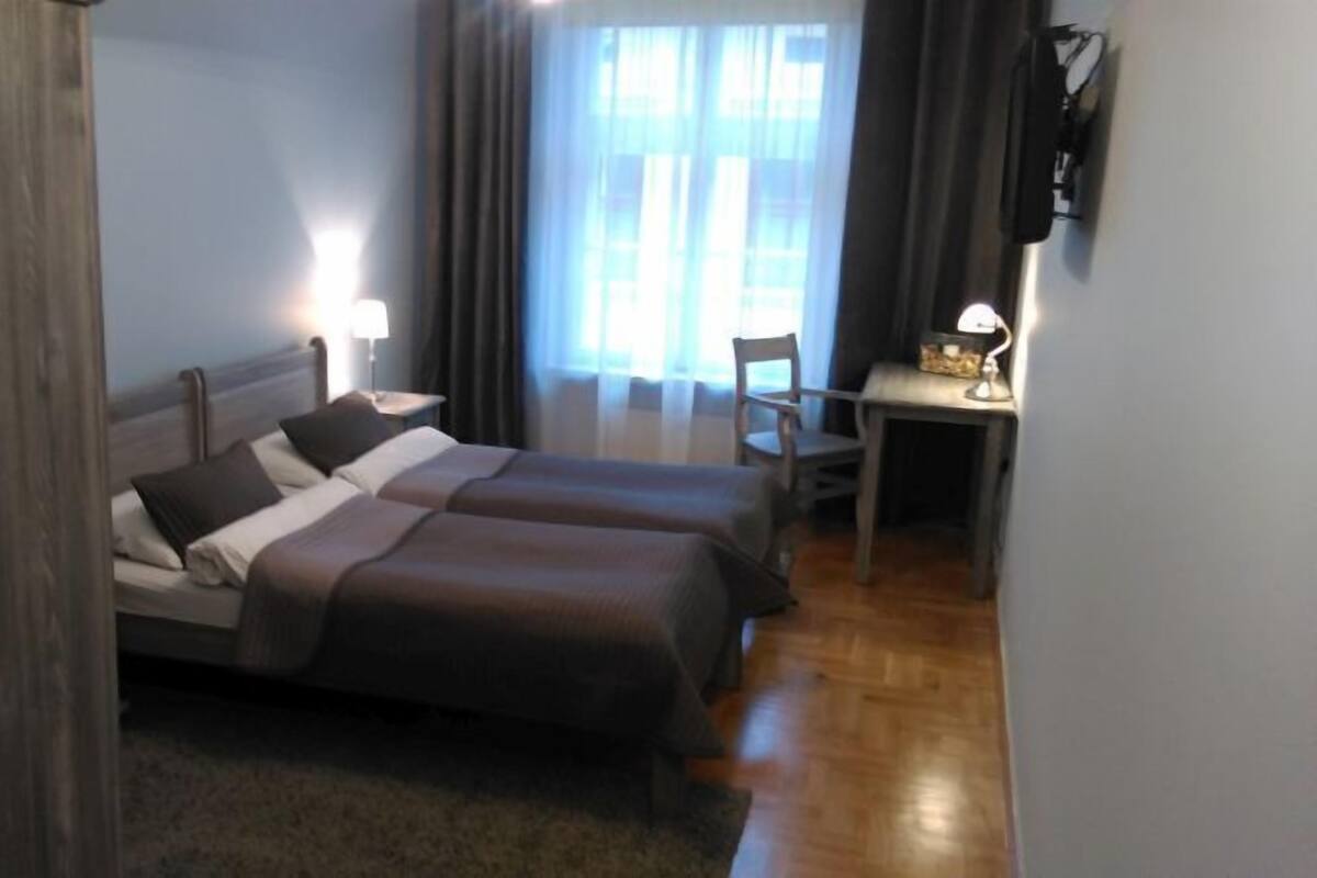 A hotel room with a bed, a desk, and a chair.