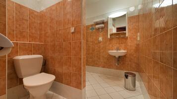 A bathroom with a toilet, sink, and tiled walls.