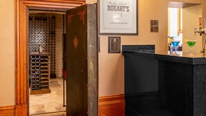 A hotel lobby with a wine rack, a framed sign for Bogart's Bar, and a bar area with a mirror and glasses. - Cathedral Quarter Hotel - Derby (Derby)