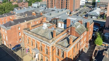 Um edifício grande e histórico com vários andares, uma entrada imponente e um pátio.