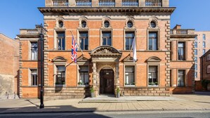 A historic brick building with a symmetrical facade, large windows, and a central entrance with a decorative arch. - Cathedral Quarter Hotel - Derby (Derby)