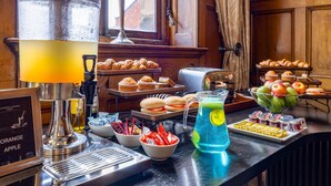 A breakfast buffet with various pastries, a pitcher of orange apple juice, and a pitcher of blue lemonade. - Cathedral Quarter Hotel - Derby (Derby)