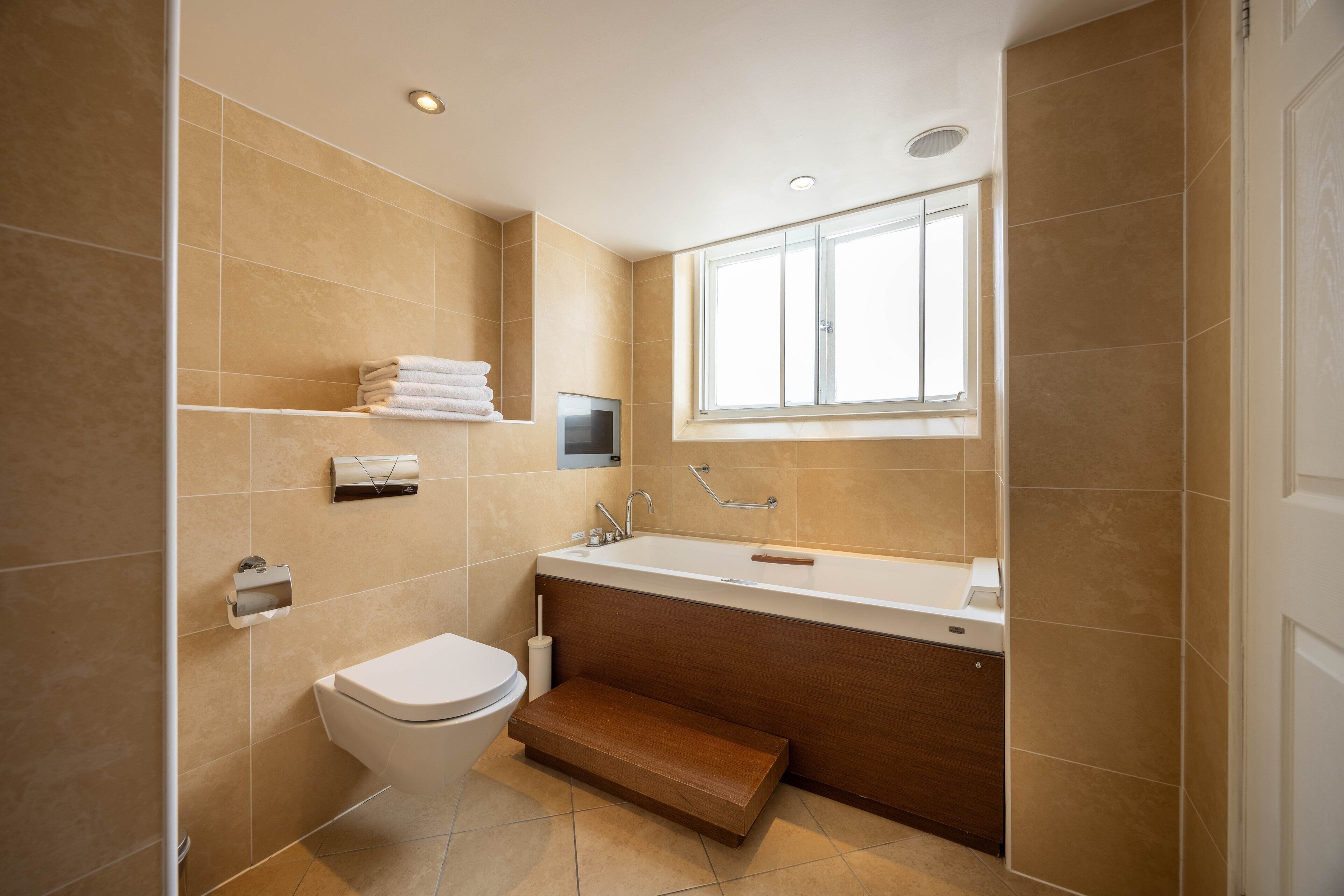 A modern bathroom with a toilet, sink, and bathtub.