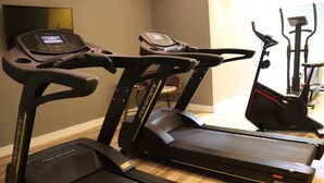 Un gimnasio en casa con cintas de correr, bicicletas estáticas y elípticas.