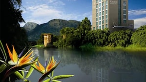 Un moderno edificio de hotel con una vista despejada del paisaje natural circundante, incluyendo un río y montañas.