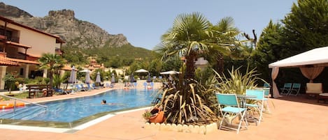 Piscine extérieure en saison, chaises longues