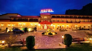 A hotel with a prominent sign, a well-lit entrance, and a paved driveway. - Famissi Eden Hotel (Kalabaka)