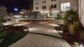 A hotel with a circular driveway, outdoor seating area, and a large truck parked in front. - ibis La Roche sur Yon (Mouilleron-le-Captif)