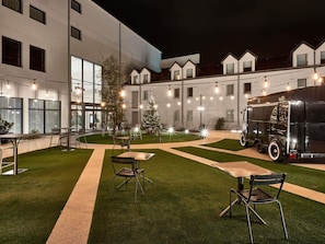 A courtyard with outdoor seating, a Christmas tree, and a vintage truck. - ibis La Roche sur Yon (Mouilleron-le-Captif)