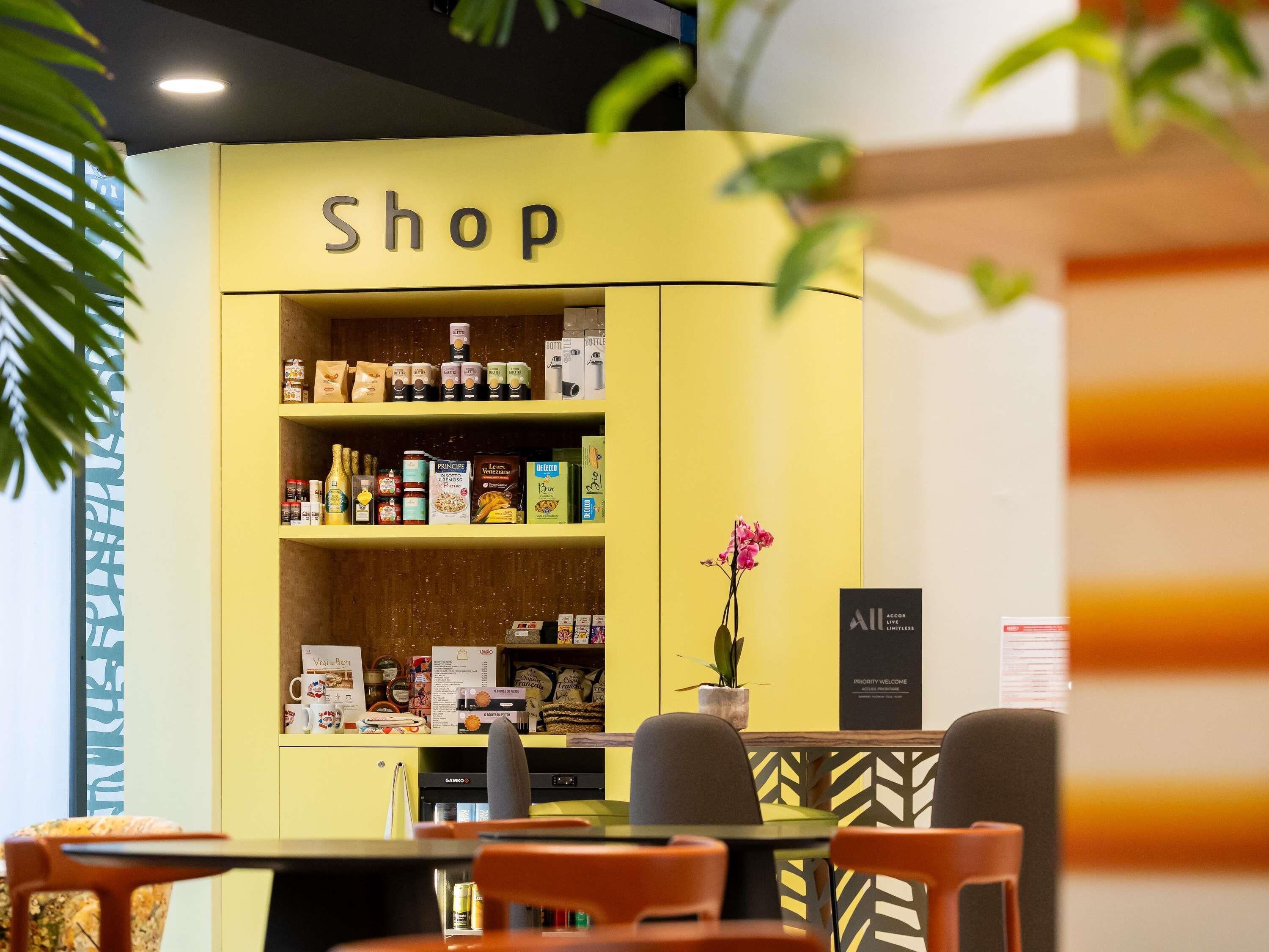 A yellow shop counter with various food products and a sign that reads 'Shop'.