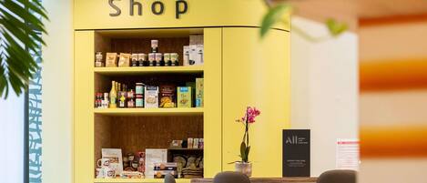 A yellow shop counter with various food products and a sign that reads 'Shop'.