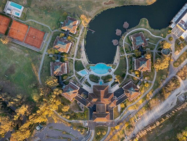 Vista aérea de una zona residencial con piscina central, varias casas y un campo deportivo.