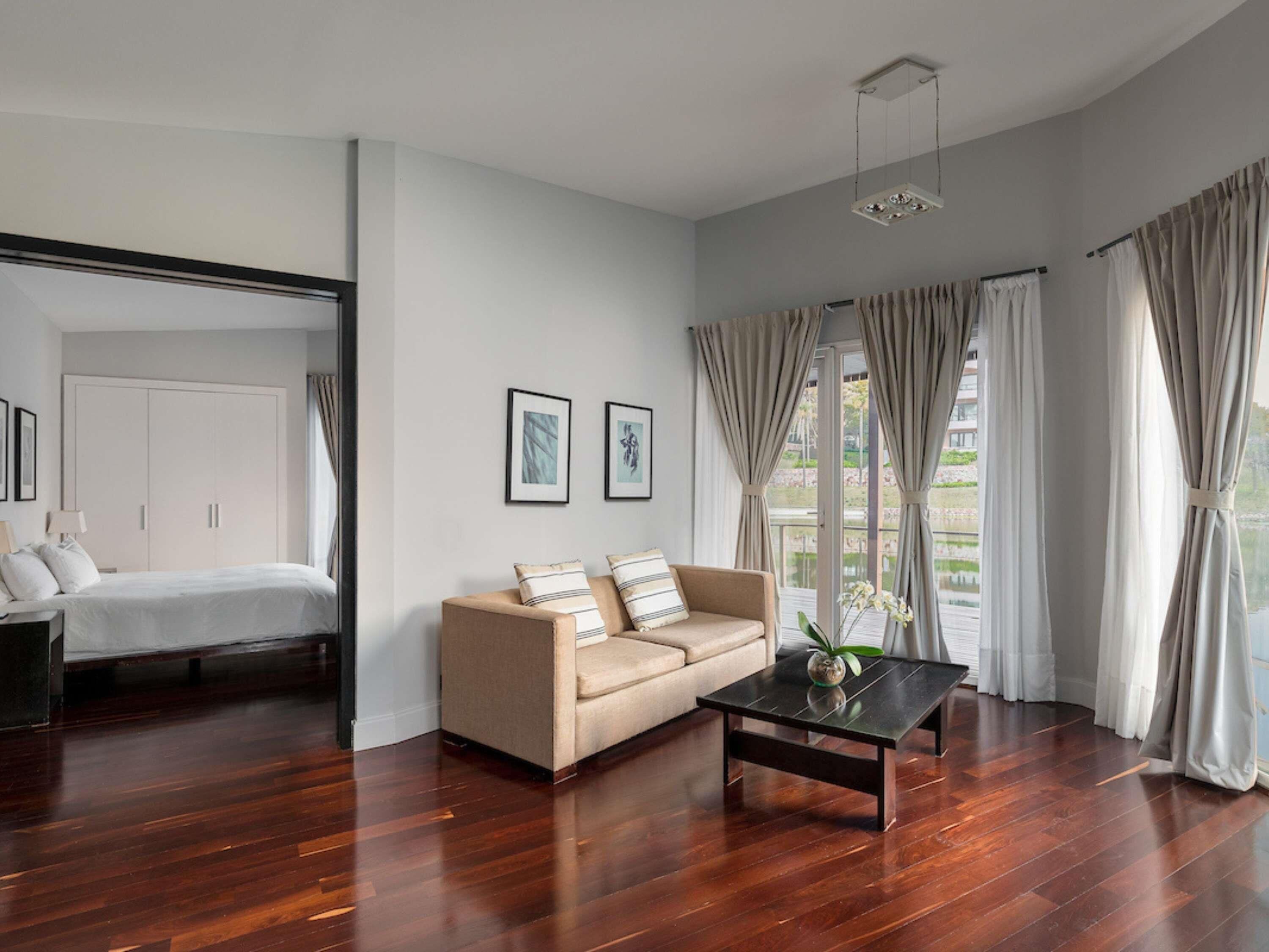 A modern living room with a sofa, a coffee table, and a bed with a wardrobe.