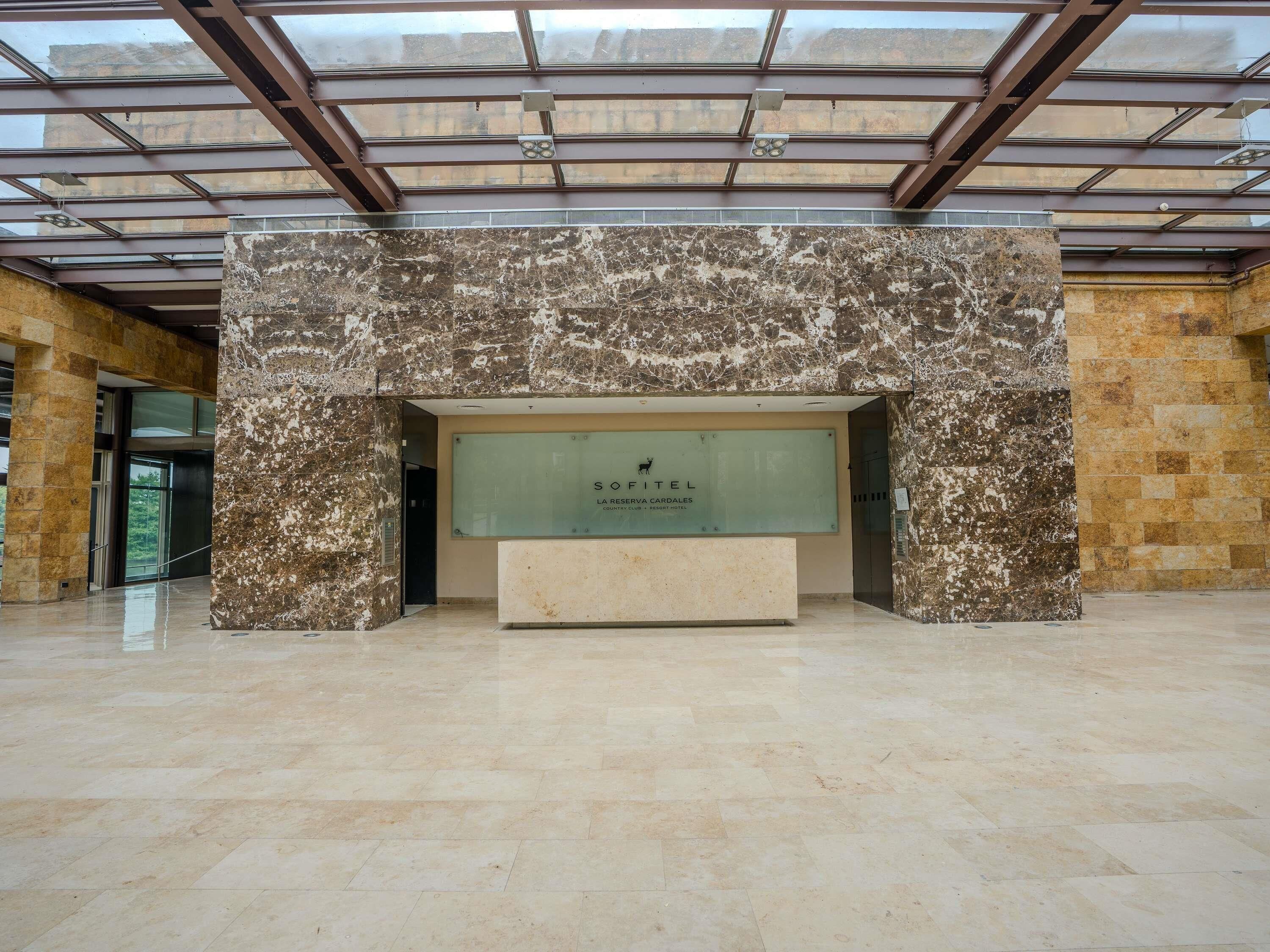 A reception area with a marble wall, a glass display case, and a reception desk.