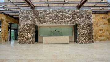 A reception area with a marble wall, a glass display case, and a reception desk.