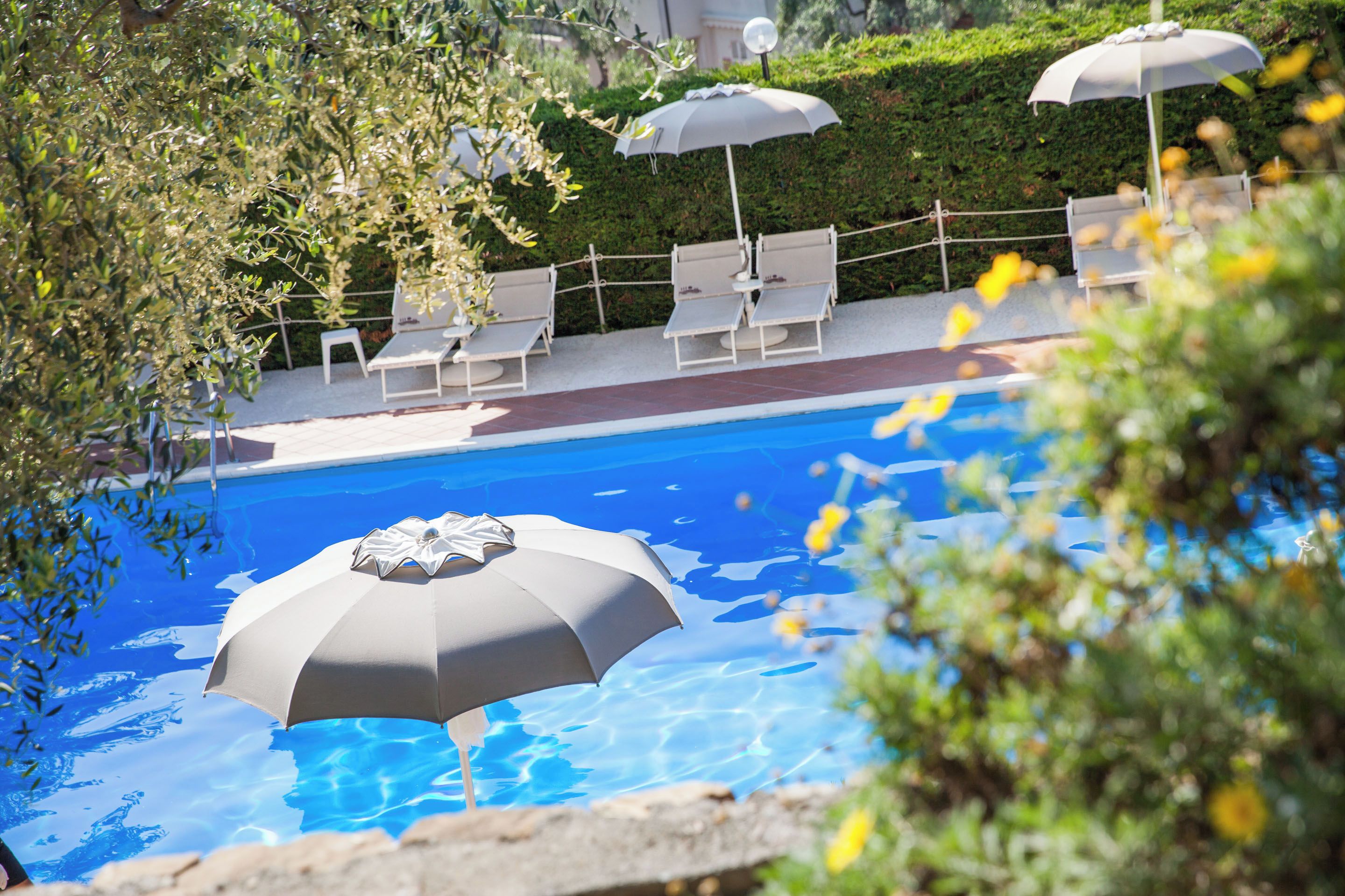 A swimming pool with lounge chairs and umbrellas.