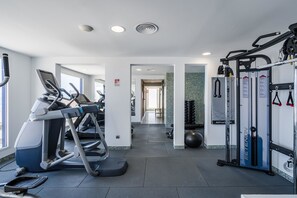 Ein Fitnessstudio mit Laufbändern, Fahrrädern und Gewichten.