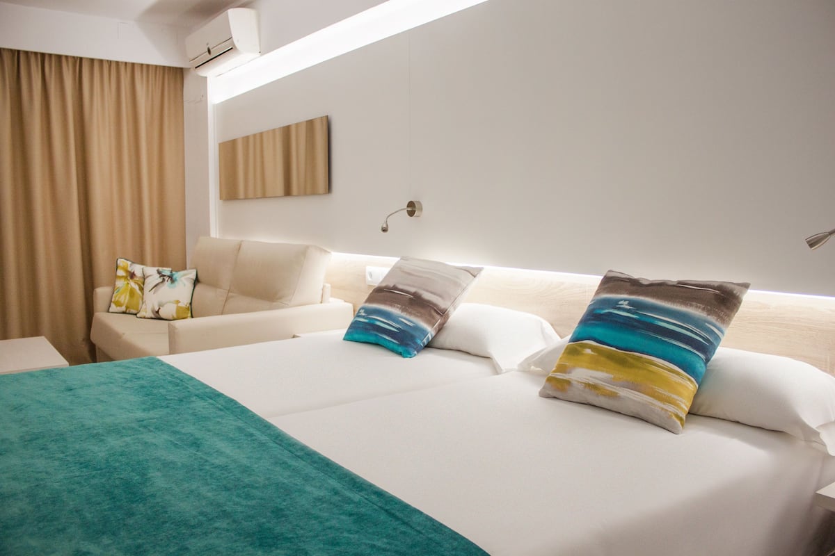 Habitación de hotel con una cama grande, un sofá y un escritorio.