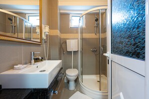 Ein modernes Badezimmer mit Waschbecken, Toilette und einer Duschkabine.