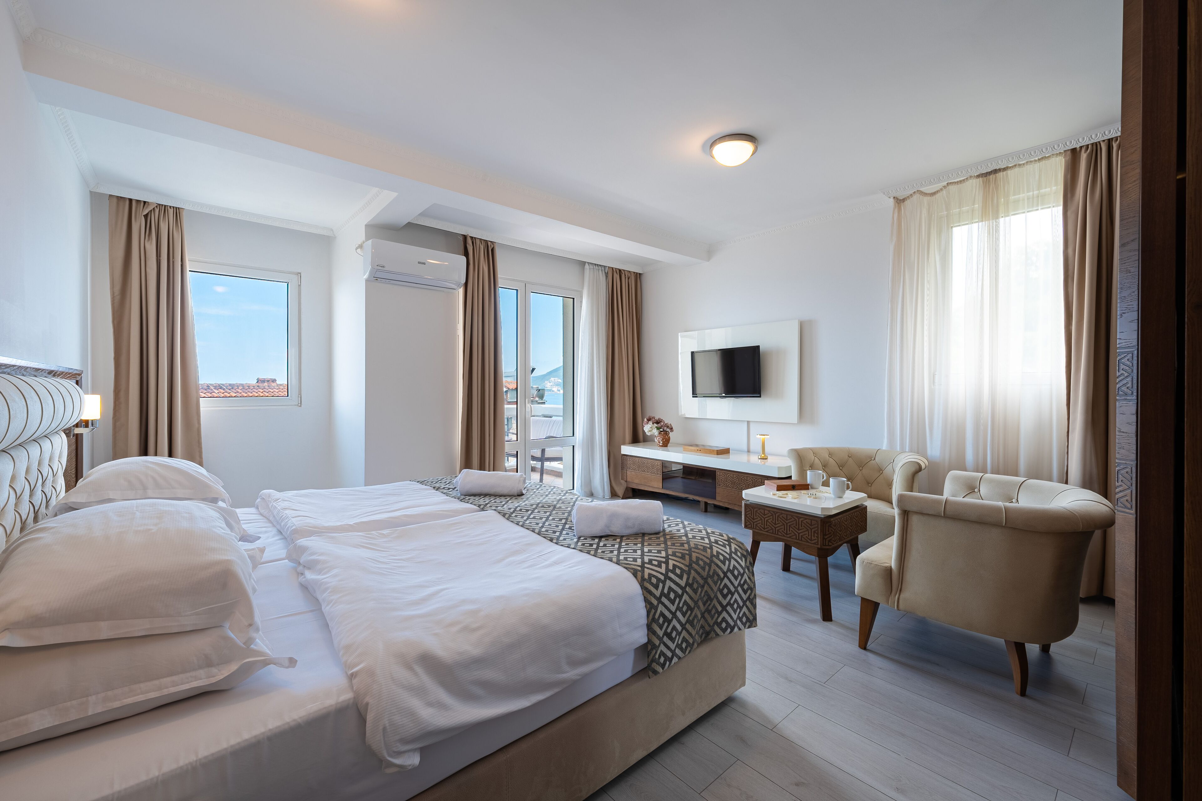 Une chambre d’hôtel avec un grand lit, un bureau, une chaise et un téléviseur.