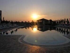 Piscine extérieure, parasols de plage, chaises longues
