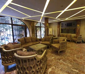 A spacious lounge area with a sectional sofa, armchairs, and a patterned coffee table. - Indiana Hotel Cairo (Giza)